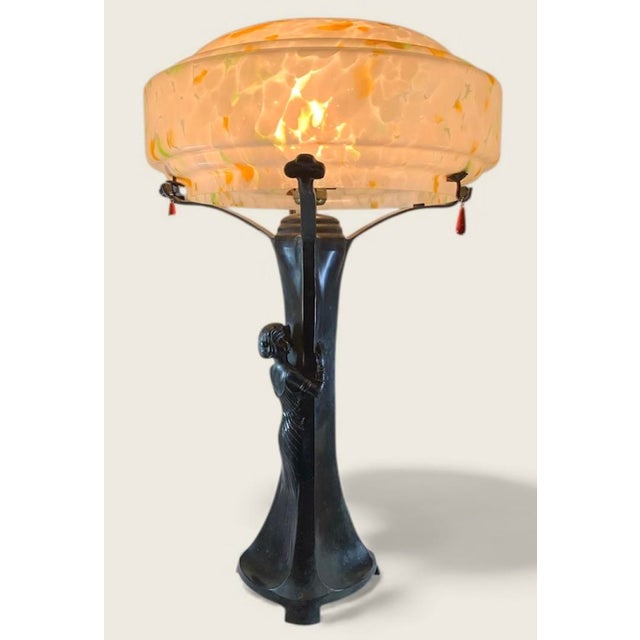 24” high, shade 14” wide. Tapered shaft on a curved triangular base, with a female figure nestled against it growing out...