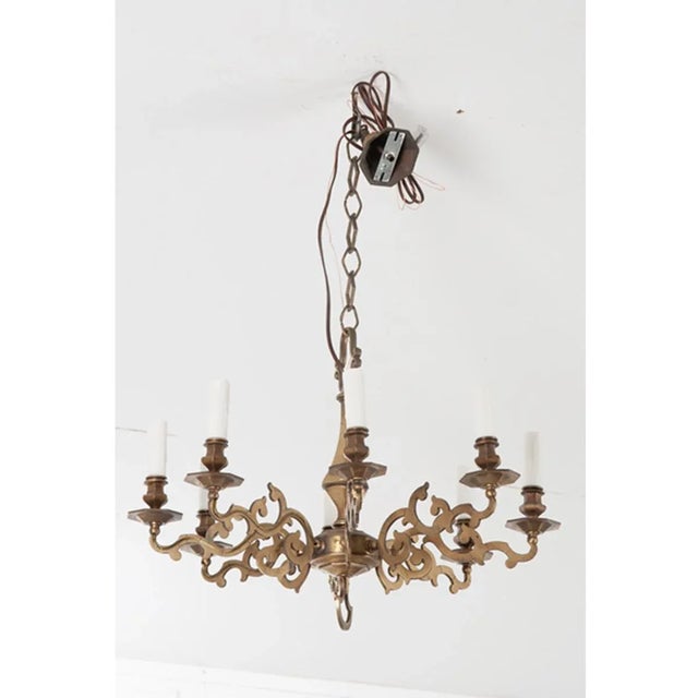 An elegant brass chandelier from 19th century France to elevate any space. Eight scrolling arms and unique shaped chain...