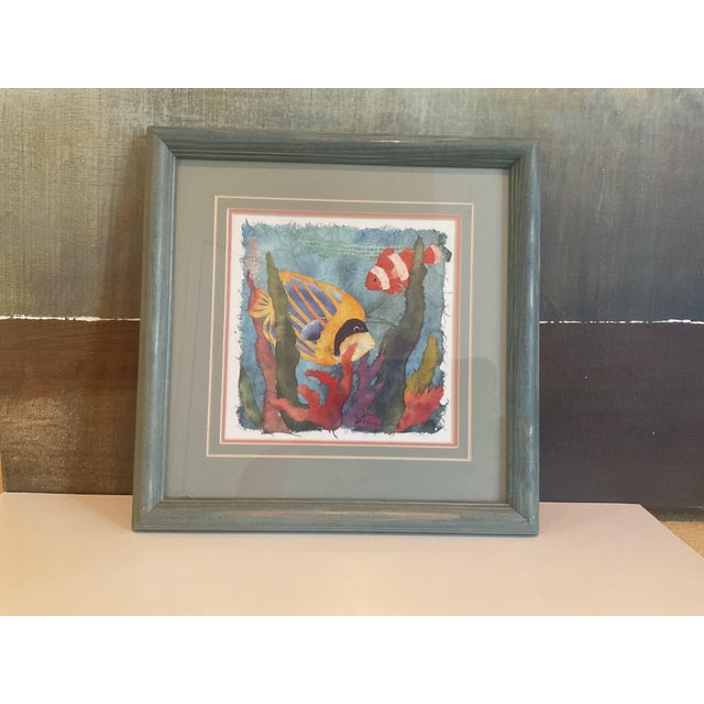 Bring a splash of ocean color to your space with this charming watercolor painting featuring two tropical fish swimming...