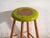 This antique wooden stool is a three-legged seat with a round seat and turned splayed legs joined by stretchers. It...