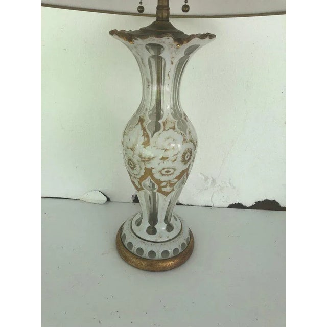 French glass lamp with gold and white floral decoration on a gilded wooden base. Recently rewired. Shade NOT included. 24"...