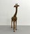 A whimsical hand-painted giraffe sculpture featuring an elongated silhouette and expressive hand-carved form. Crafted with...