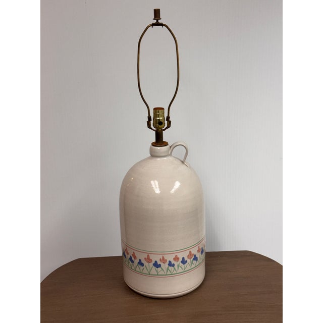 Design Plus Gallery presents a Floral Stoneware Jug Table Lamp. The ceramic jug-form base has a glossy cream glaze with a...