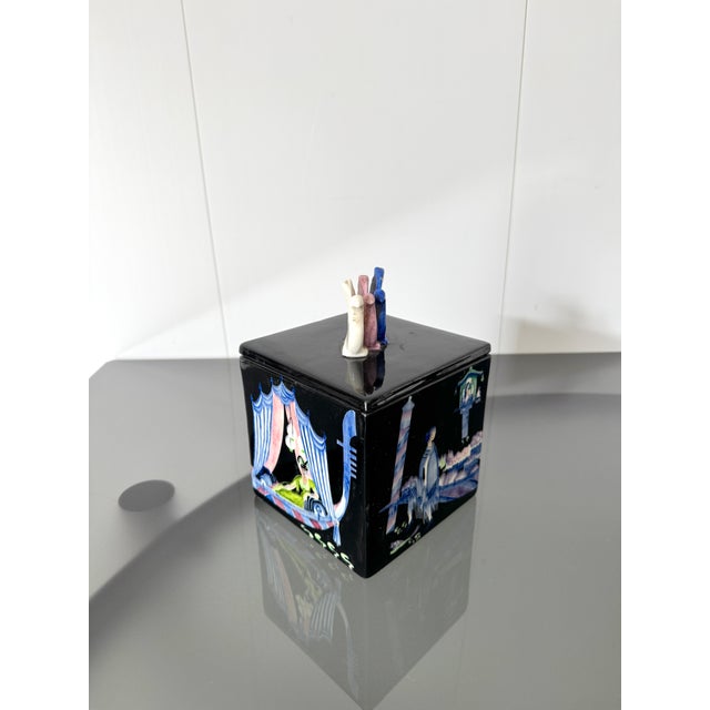 The cubic box features two different night scenes painted on the main sides, showing gondoliers and ladies in Venetian...