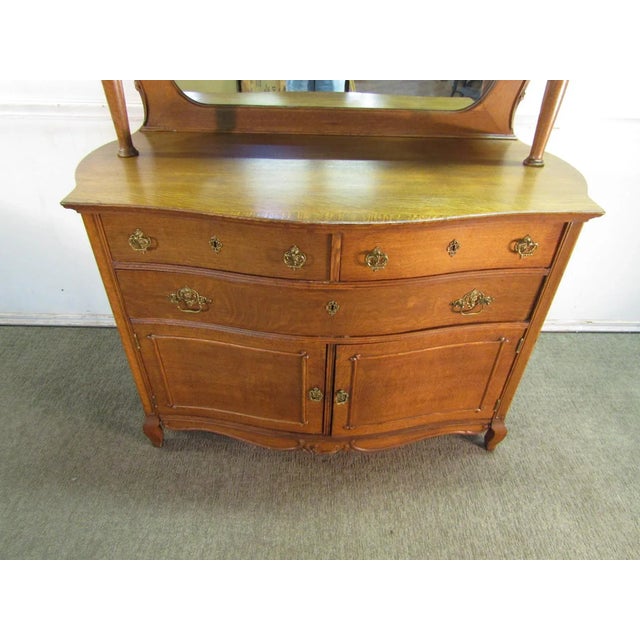 Item 81763: Quartersawn oak sideboard with mirrored top. Age: Early 1900's. Details: Beautiful carvings and two piece...