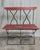 A mid-century French bistro style bench combining hand forged iron and painted wood. The frame features elegant arched...