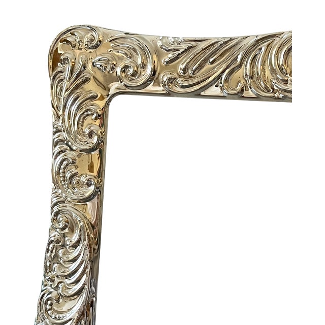 An elegant large silverplated picture frame featuring sweeping acanthus leaves, curling scrolls, and decorative oval...