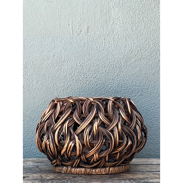 This vintage handcrafted woven rattan basket showcases the artistry of traditional hand weaving and likely dates to the...