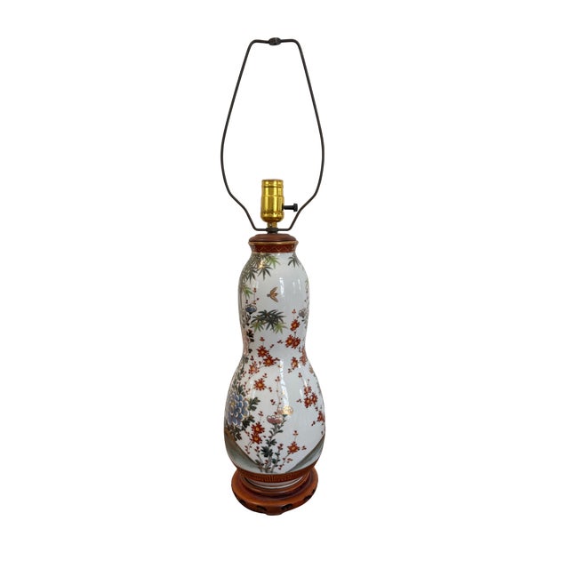 Substantial and elegant pair of 26-inch vintage porcelain table lamps featuring richly layered chinoiserie-inspired floral...