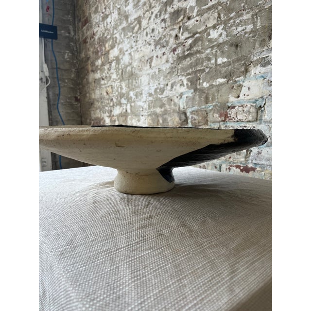 "A sculptural statement piece for any tabletop. This handcrafted ceramic bowl features a striking yin-yang glaze in matte...