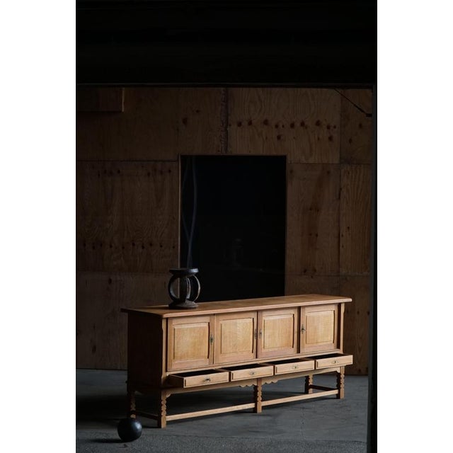 A beautiful Danish Mid-Century low sideboard in oak by Henning (Henry) Kjærnulf, 1960s. This piece displays the hallmarks...