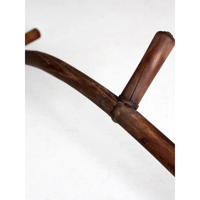 This is an early 20th century antique hay scythe. The primitive sling blade features a long wood handle with double holds...