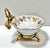 A gorgeous gilt gold-detailed and porcelain soap dish. It sits in a gilt metal floral and tassel footed base. Dimensions...