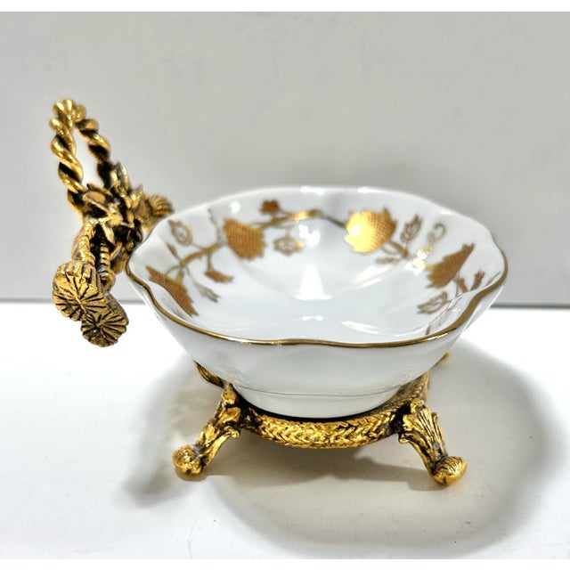 A beautiful vintage porcelain vanity dish set in an ornate gilt metal ormolu stand. The delicate gold leaf pattern and...
