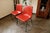 Pair of red plastic chairs from the 1980s featuring molded plastic seats and sturdy metal frames. Their minimalist and...