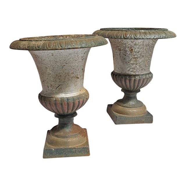 2 antique cast iron urns or planters in the Medici style. Features a Fluted design and a square base.most probably by...