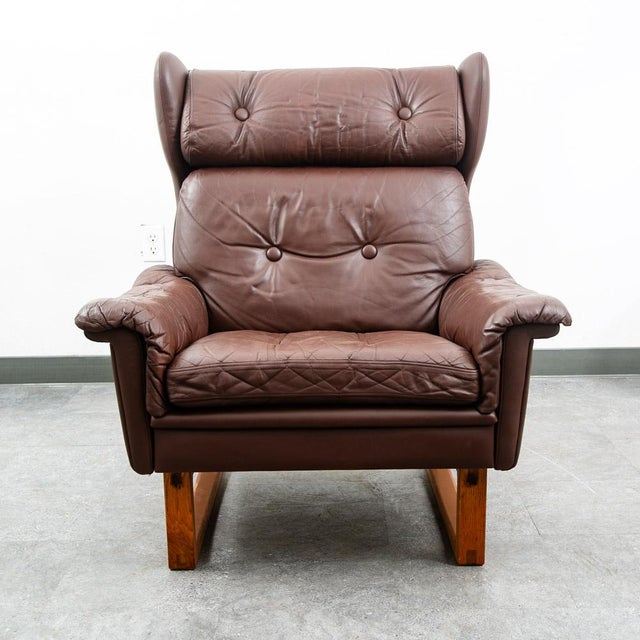 Chocolate brown wingback lounge chair on oak sled style base. Classic and timeless look. Imported directly from Denmark in...