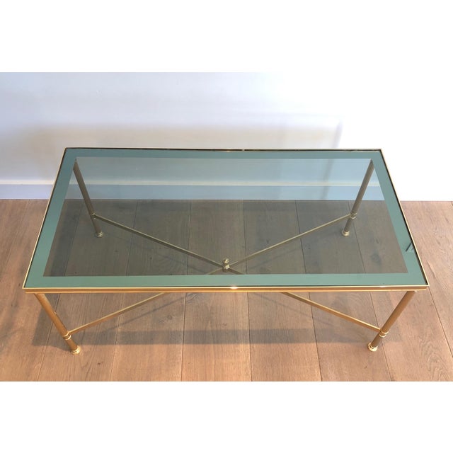 This beautiful neoclassical-style coffee table is made of gilded metal with a blueish glass top. It is a French work in...