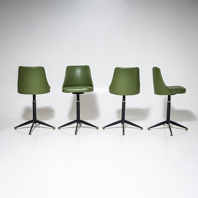 Set of four bar stools with green leather upholstery and black-lacquered frames with brass feet. The stools are height-...