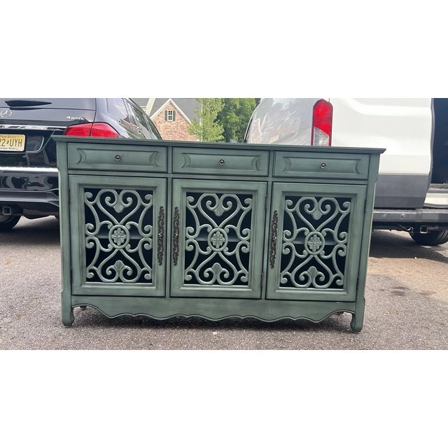 Elevate your space with this vintage-inspired 3-door accent credenza, featuring a distressed muted teal-slate finish and...
