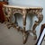Regency style marble top console table with a cream and tan veined top and shaped edge. The finish is a subdued silver,...
