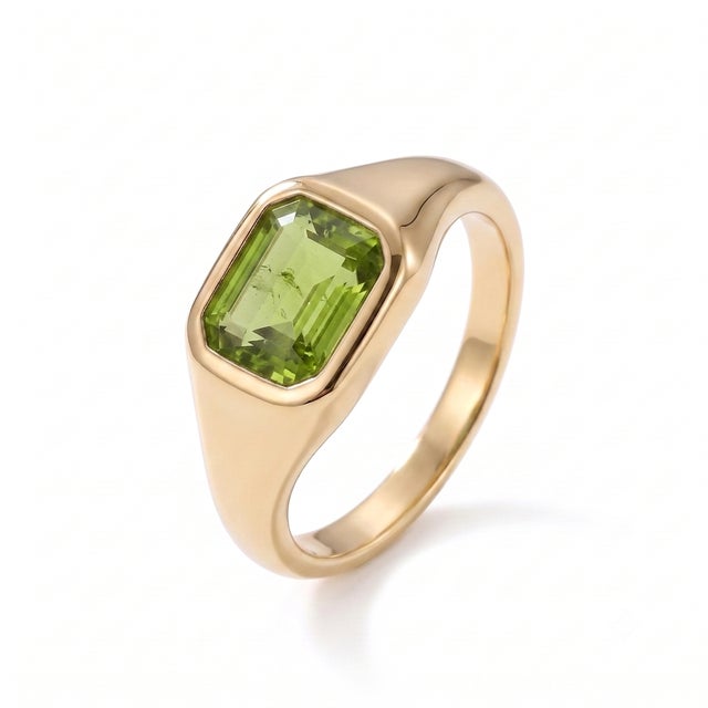 A modern interpretation of the classic signet ring, this elegant design showcases a lively peridot in a sleek bezel...