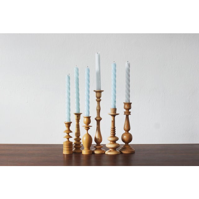 A set of six vintage wooden candleholders, whose varied, turned shapes create a cohesive and exceptionally decorative...