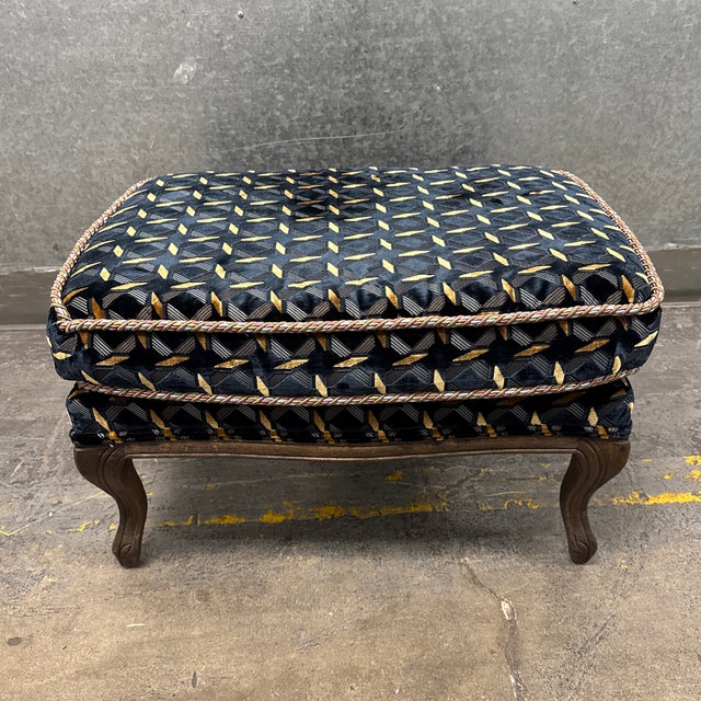 Design Plus Gallery presents a Traditional Geometric Velvet Ottoman. This upholstered footstool showcases a black velvet...