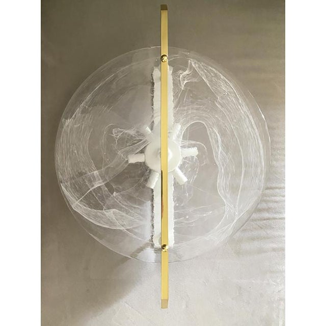 Scenographic fashion wall light in transparent and venied-white "alabastro" murano glass disc and brass metal frame by...