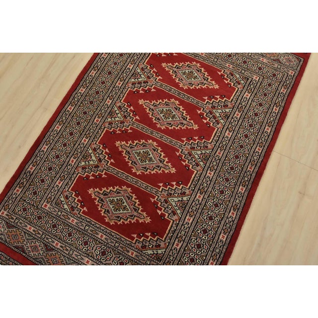 A tribal Bokhara Jaldar rug hand-knotted with fine wool on a cotton foundation. This rug features geometric medallions set...