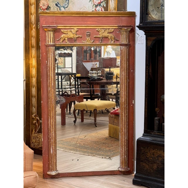 Early 19th C Continental Neoclassical mirror, the red painted frame with parcel-gilt ornament, the frieze applied with a...