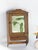 Small antique wooden wall cabinet with a rectangular mirror in the front door and a floral decorated drawer. The...