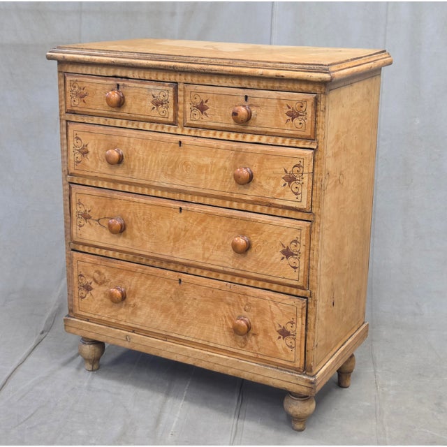 A charming late 19th century English pine faux bois painted birds eye maple chest of drawers with decorative stringing and...