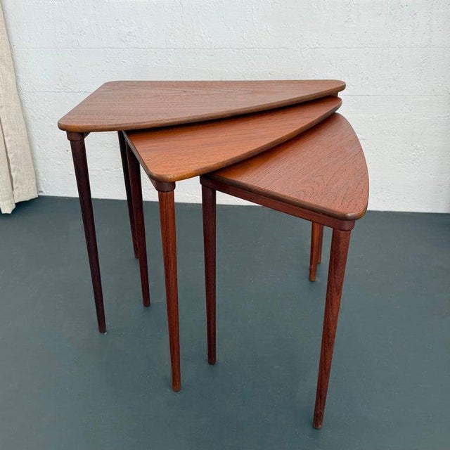 This set of three Scandinavian Modern teak nesting tables were manufactured by Selig circa the 1960s. The tables feature a...