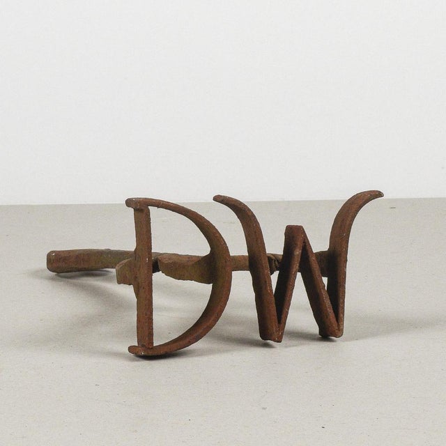 This ancient tool is a hand-forged fire stamp, intended for branding livestock. Made of solid iron, it has a patina of...