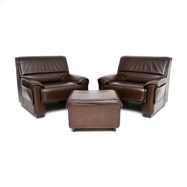 A superb pair of vintage leather armchairs and stool by De Sede, made in Switzerland and dating from around the 1960’s....