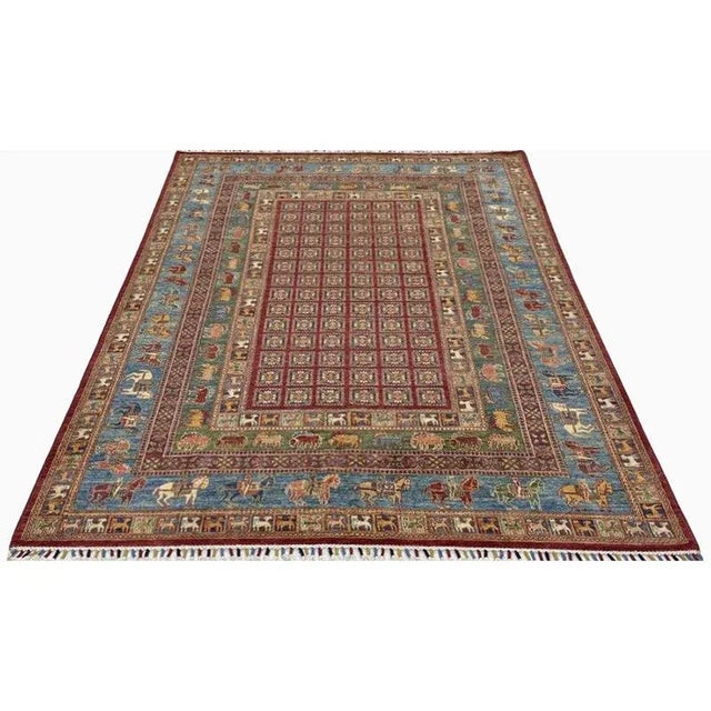 Handwoven Turkmen area rug features an allover design field and animal print design in the border. Accent colors include...