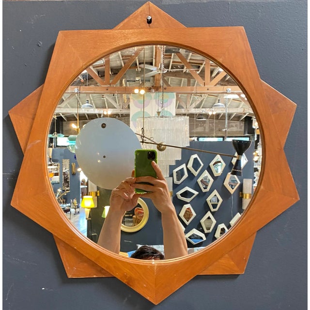 956 Exclusive Wall mirror by Ico Parisi "Mira" Model 2002. A round mirror is framed by two pentagonal shapes made of teak...