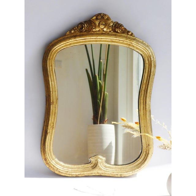 A well made heavy antique Italian gold gilt mirror. The mirror has a wonderful scalloped frame with gold leaf and a...