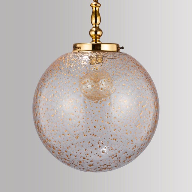 Offered is a rare and amazing hanging lamp with a spherical, transparent glass shade from the 1970s. amazing because when...