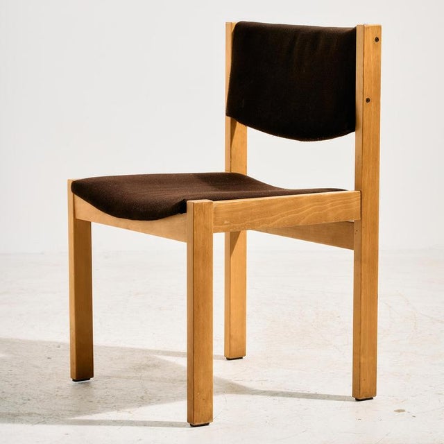 Angular oak chair from the 1970s. The surface of the chair has scratches, stains and wear in places.