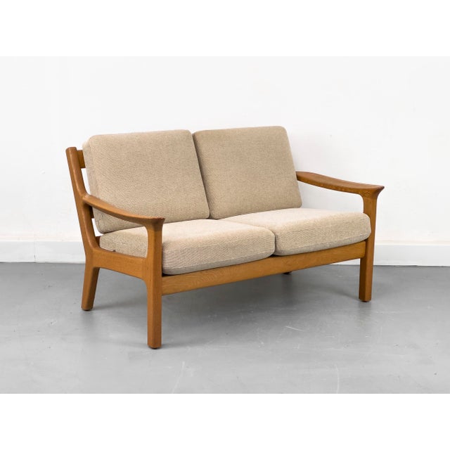 High-quality two-seater sofa made of solid oak. Spring core cushions upholstered in a textured beige fabric. •...