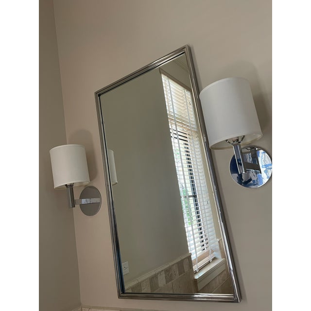 A handsome pair of modern sconces in gleaming polished chrome, with a clean circular backplate and a squared,...