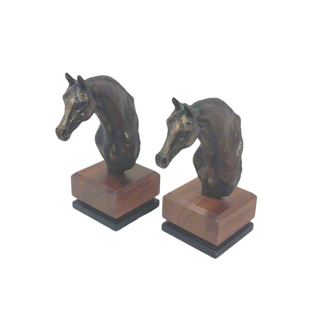 A pair of stunning bronze look resin horse bust bookends on teak and black bases. Signed Jo Stafford with a copyright mark...