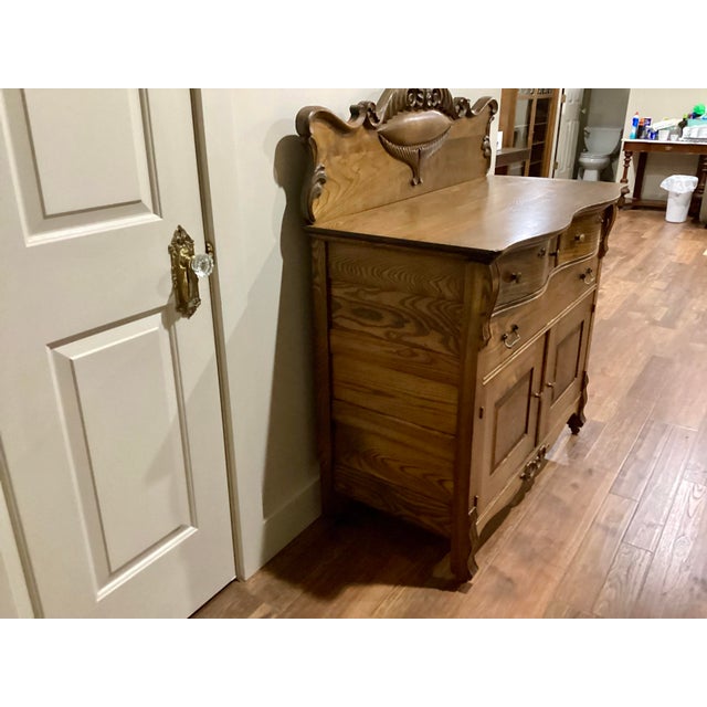 This antique solid oak sideboard from the 1800s features intricate carvings and is all original. With two doors and a...