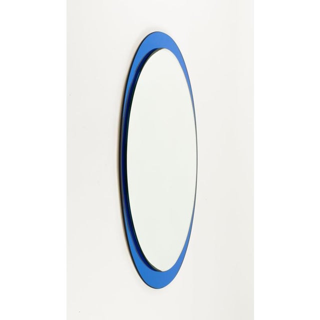 Midcentury amazing oval wall mirror with blue colored mirror frame by Metalvetro Galvorame. Made in Italy in the 1970s. It...