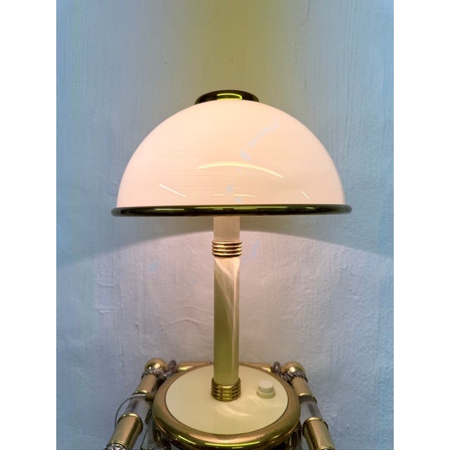 One Italian table lamp from the 1970s/80s, two-light, E27 socket. Brass, cream-white lacquered metal, Murano glass. Good...