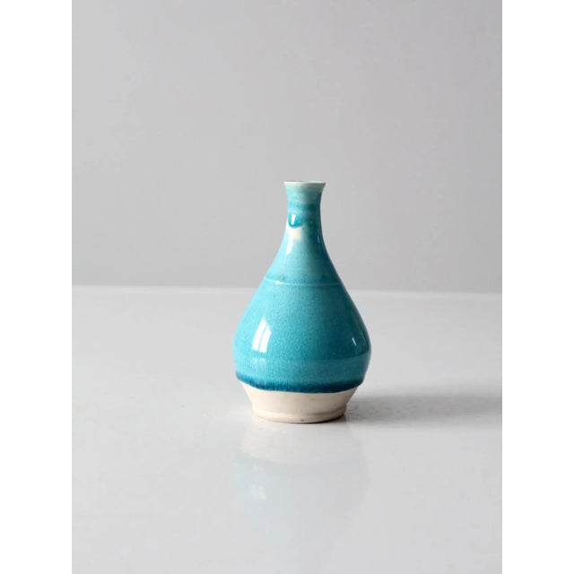 This is a studio pottery bottle-neck vase. The hand-crafted bud vase has a vibrant turquoise blue glaze. Vase signed and...