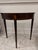 An elegant Federal style demilune console table by the renowned Baker Furniture Company. Authentic Baker Furniture piece...