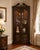 A striking corner display cabinet attributed to Hekman, designed to bring both elegance and practicality to a traditional...